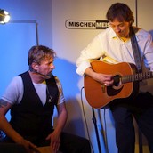 Mischenmeister spielen akustisch Songs auf einem Event